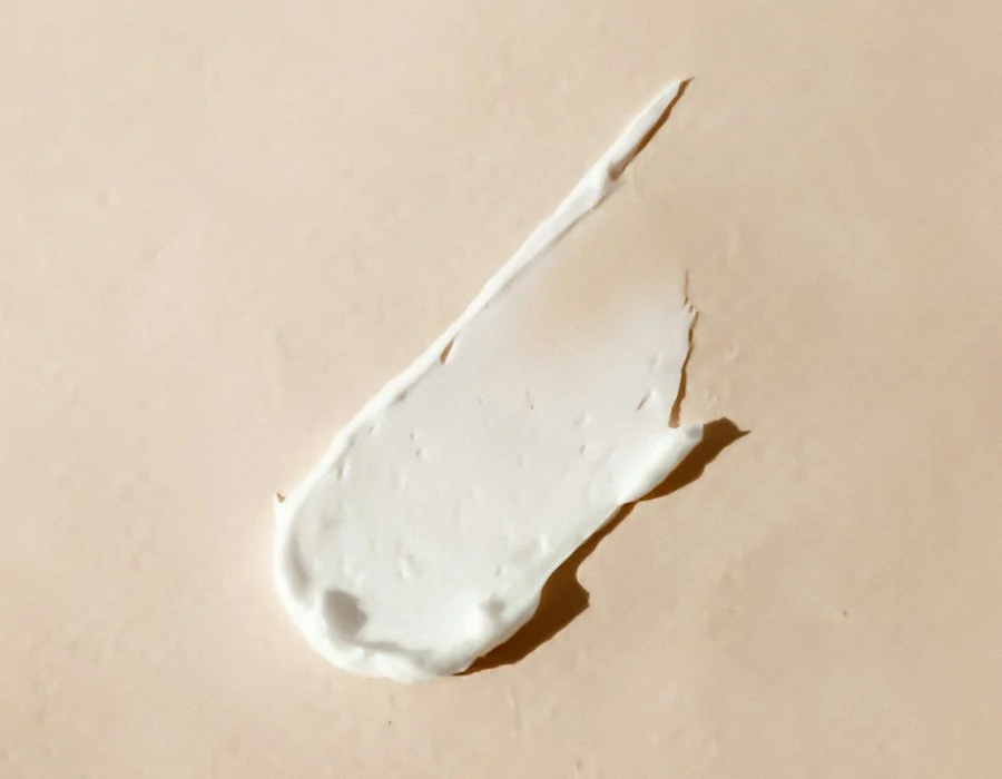 Smear of white cream on a beige surface